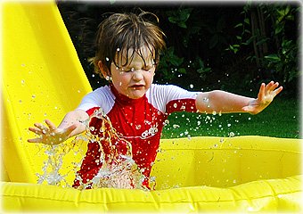 child splashing in pool